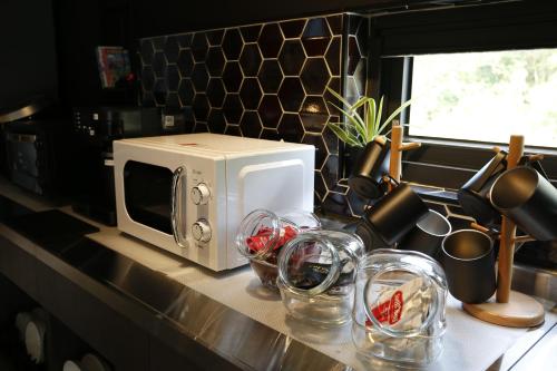 a kitchen counter with a microwave and wine glasses at Walking Island in Xiaoliuqiu