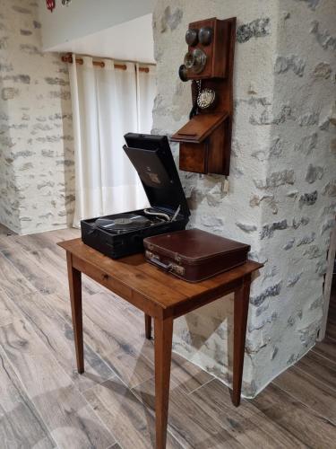 ein Schreibtisch mit einem Laptop und einer Aktentasche darauf in der Unterkunft Château de la Cressonnière in Antigny