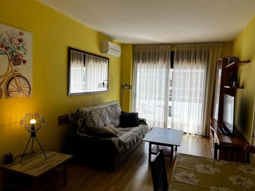 ein Wohnzimmer mit einem Sofa und einem Tisch in der Unterkunft Hermoso apartamento con piscina a 300m de la playa in Lloret de Mar
