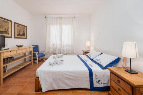 a bedroom with a bed with a television and a desk at Casa Erica in Palau