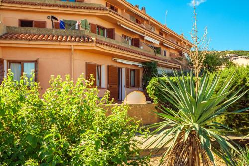 a building with a palm tree in front of it at Casa Erica in Palau