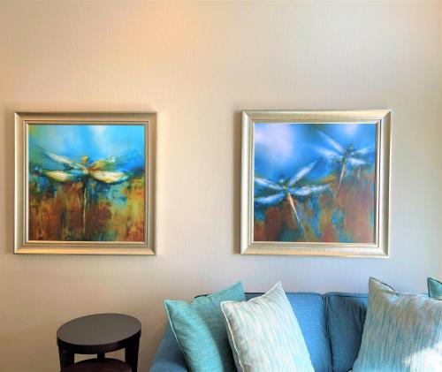 two pictures of butterflies on a wall next to a couch at Premier Hotel Cape Town in Cape Town