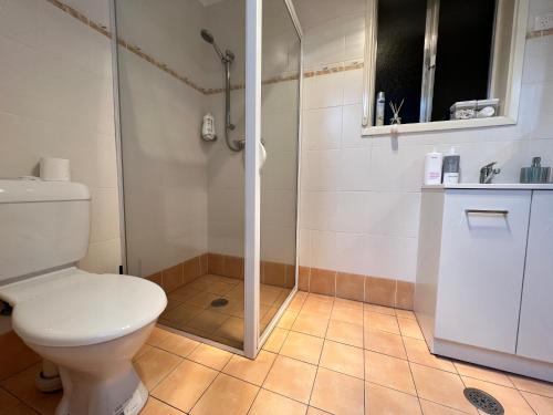 a bathroom with a toilet and a shower at Cheerful Comfortable Home in Higgins Wine Parking Wifi in Weetangerra