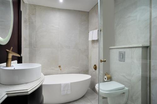 a bathroom with a tub and a sink and a toilet at Premier Hotel Cape Town in Cape Town