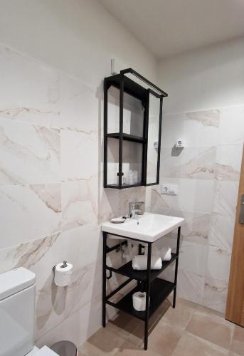 a white bathroom with a sink and a mirror at Hotel El Panorama in Tapia de Casariego