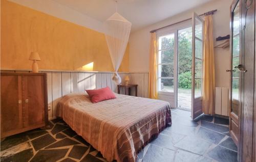 ein Schlafzimmer mit einem Bett mit einem roten Kissen darauf in der Unterkunft Cozy Home In Saint-georges-dolron With Kitchen in Saint-Georges-dʼOléron