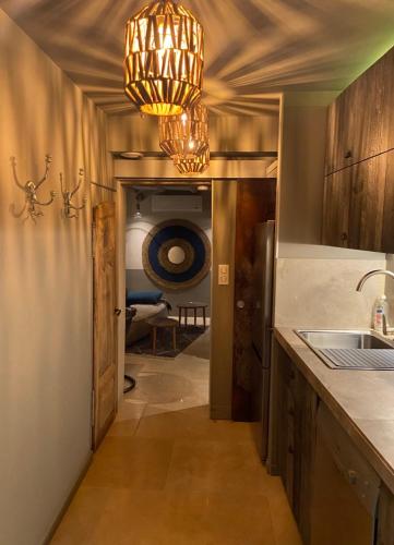 Il dispose d'une cuisine avec un évier et un lustre. dans l'établissement PRIVATE ROOM & SPA avec Jacuzzi privatif, à Lorgues