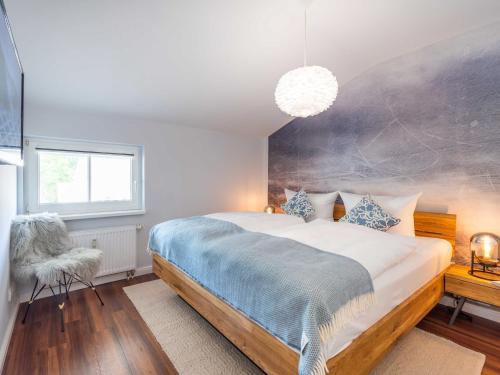 a bedroom with a large bed with a blue blanket at OSTSEELOFT BINZ - Villa Amanda WG 08 in Binz