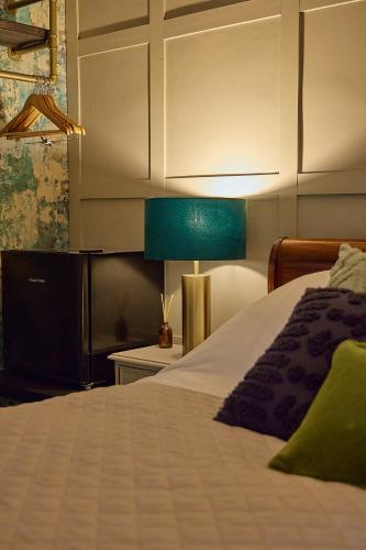 a bedroom with a bed and a green lamp at The Ribchester Arms in Blackburn