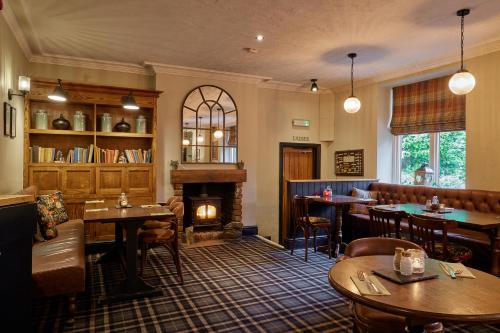 a restaurant with a fireplace and tables and chairs at The Ribchester Arms in Blackburn