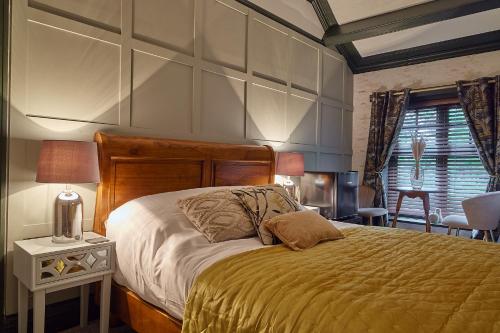 a bedroom with a large bed with a yellow blanket at The Ribchester Arms in Blackburn