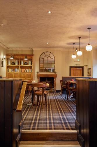a living room with tables and a fireplace at The Ribchester Arms in Blackburn