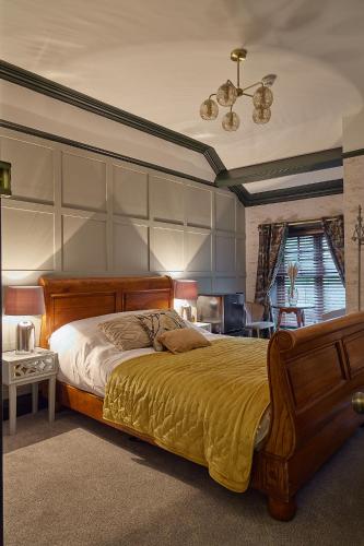 a bedroom with a large bed with a wooden headboard at The Ribchester Arms in Blackburn