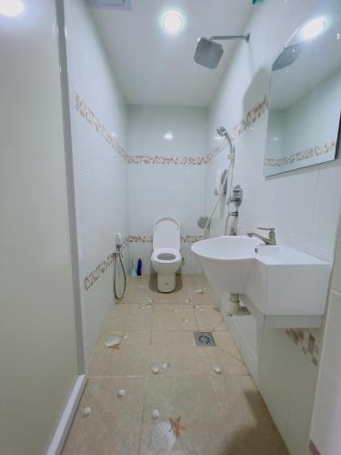 a white bathroom with a sink and a toilet at Noor Hotel Kangar in Kangar
