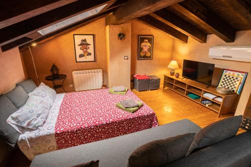 a living room with a bed and a tv at Sierra de Gata EL CORRAL DE LA HIGUERA in Torre de Don Miguel