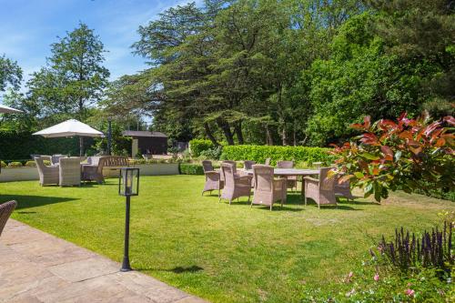 a group of chairs and a table in the grass at The Pheasant Hotel, Holt, Norfolk - The Coaching Inn Group in Kelling