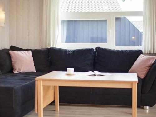 a black couch with a coffee table in a living room at 6 person holiday home in GROEMITZ in Grömitz