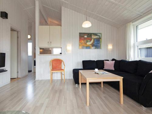 a living room with a black couch and a table at 6 person holiday home in GROEMITZ in Grömitz