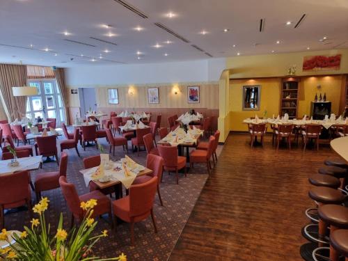 a restaurant with tables and chairs in a room at PLAZA INN Leonberg in Leonberg