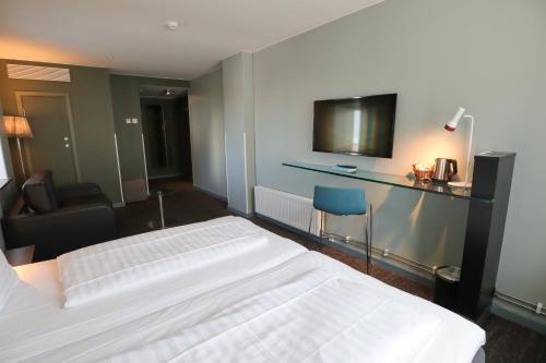 a hotel room with a bed and a television at Comfort Hotel Malmö in Malmö
