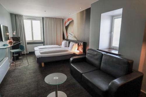 a living room with a couch and a chair and a table at Comfort Hotel Malmö in Malmö