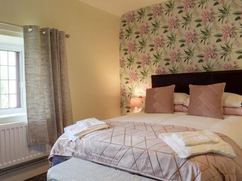a bedroom with a bed with a floral wall at The Ramparts in Montgomery
