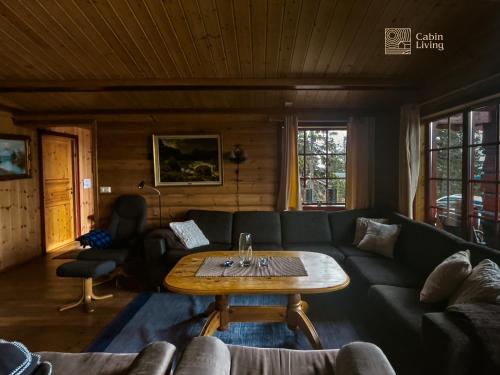 uma sala de estar com um sofá e uma mesa em Large Cottage 2 Baths and Sauna in Sjusjøen em Lillehammer
