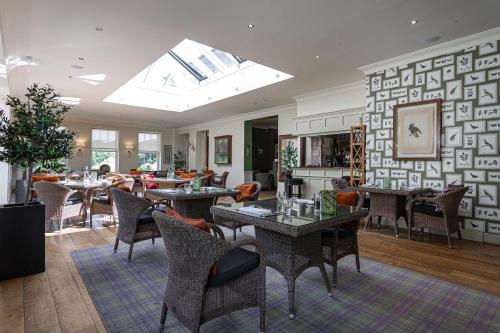 a living room with tables and chairs and a skylight at The Pheasant Hotel, Holt, Norfolk in Kelling