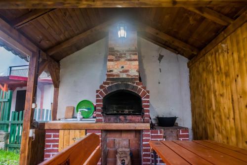 an outdoor fireplace in a house with a bench at Casa Flavius in Văliug
