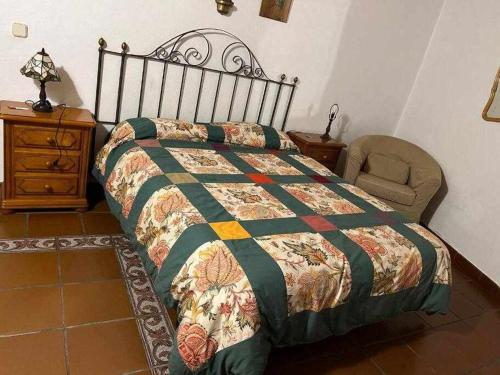 a bedroom with a bed and a chair and a dresser at Tía Clotilde es una casa grande ideal para familias y grupos de amigos in Cabezas Bajas