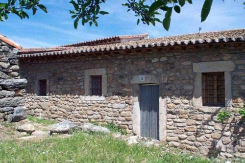 an old stone house with a stone wall at Tía Clotilde es una casa grande ideal para familias y grupos de amigos in Cabezas Bajas