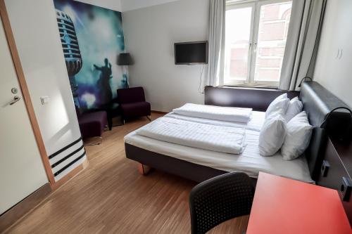 a hotel room with a bed and a window at Comfort Hotel Malmö in Malmö
