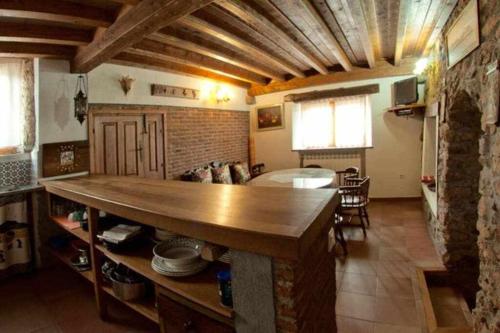a kitchen and living room with a large wooden table at Casa Tía Modesta es una cálida y acogedora casa rural in Cabezas Bajas