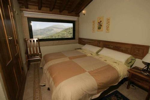 sypialnia z dużym łóżkiem i oknem w obiekcie Apartamento Rural El Labrador es un cómodo y acogedor apartamento w mieście Cabezas Bajas