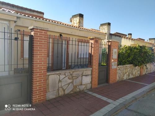 a brick building with a gate and a sidewalk at Casa Vainilla in San Miguel del Pino