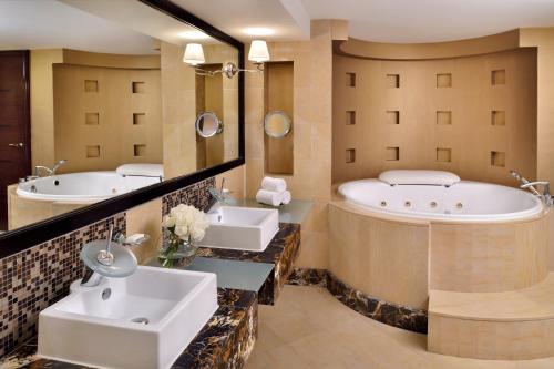 a bathroom with two sinks and a tub at InterContinental Abu Dhabi, an IHG Hotel in Abu Dhabi