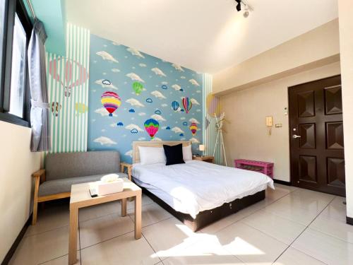 a bedroom with a bed and a wall with colorful balloons at 一中小窩馨 in Taichung