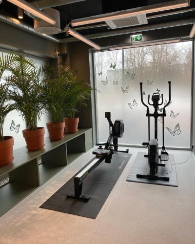 a gym with two tread machines and potted plants at Campus House by Larsen in Tallinn