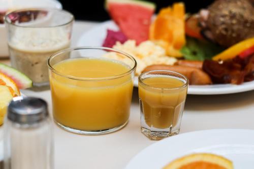 two glasses of orange juice and a plate of food at Comfort Hotel Malmö in Malmö