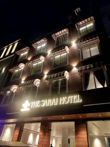 a hotel building with a sign on it at night at The Sarai, Hotel in Jaipur