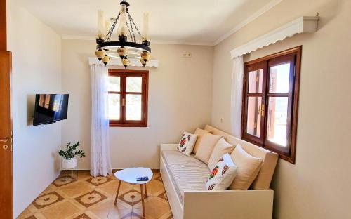 a living room with a couch and a chandelier at Kyano seaview in Olympos