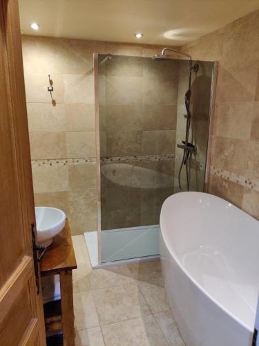 a bathroom with a tub and a sink and a shower at Spacious Ski Chalet In Traditional French Village, sleeps 8, Four Star with fibre broadband in Abondance