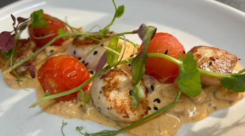 a white plate of food with tomatoes and vegetables at The Davron Hotel in Fraserburgh