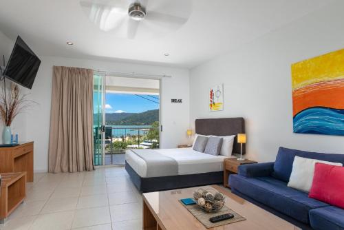 a hotel room with a bed and a couch at Waterview Airlie Beach in Airlie Beach