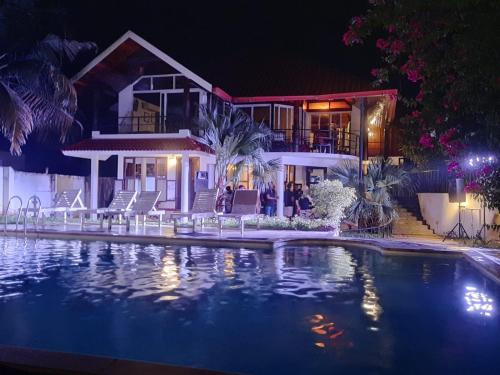 ein Swimmingpool vor einem Haus bei Nacht in der Unterkunft Petit Elephant in Cherai Beach