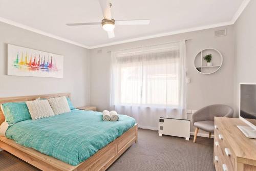 a bedroom with a bed and a desk and a window at West Beach Family Beauty - 2 Bed Unit in Henley Beach