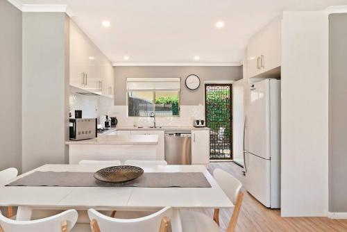 a kitchen and dining room with a table and chairs at West Beach Family Beauty - 2 Bed Unit in Henley Beach