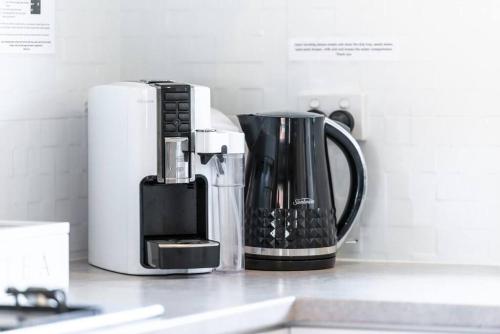 a kitchen counter with a coffee maker and a coffee pot at West Beach Family Beauty - 2 Bed Unit in Henley Beach