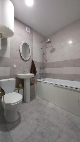 La salle de bains est pourvue de toilettes, d'un lavabo et d'une baignoire. dans l'établissement "Чернігівська тиша", à Tchernihiv
