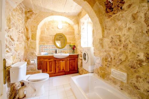 e bagno con servizi igienici, vasca e lavandino. di Gawhra Holiday Home a Xagħra